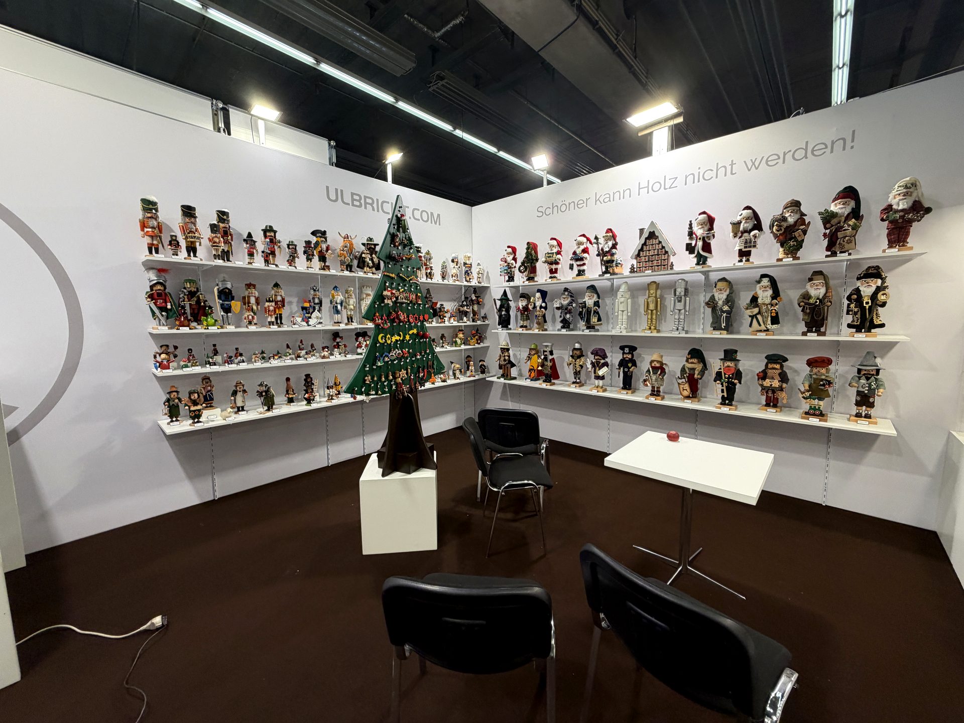 Messestand mit weißen Produktregalen und Wandgrafik