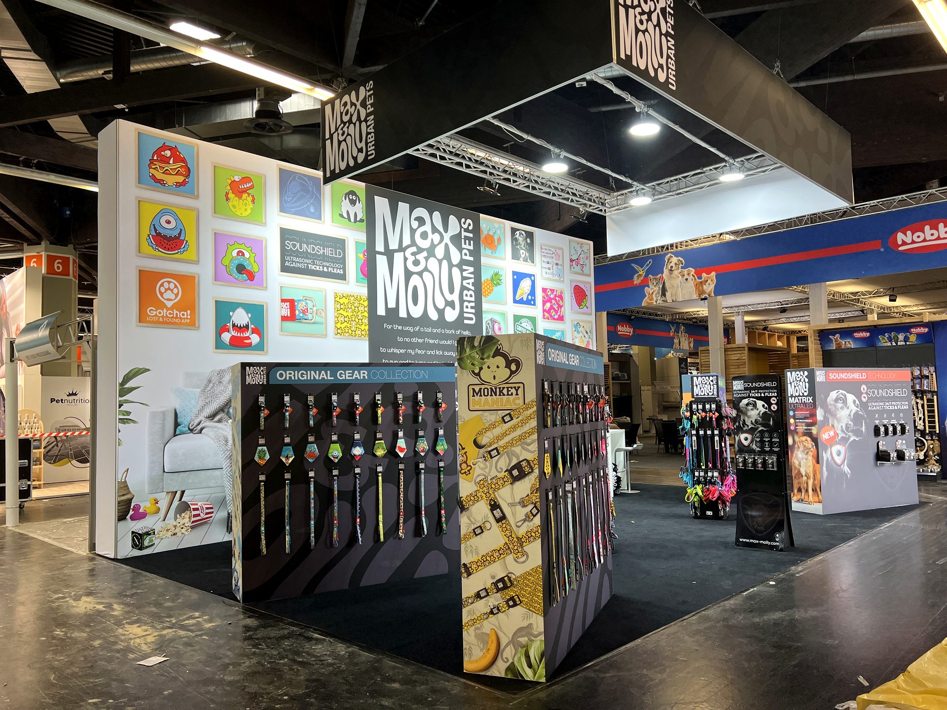 Farbenfroher Messestand mit Produktdisplays und Deckenbanner