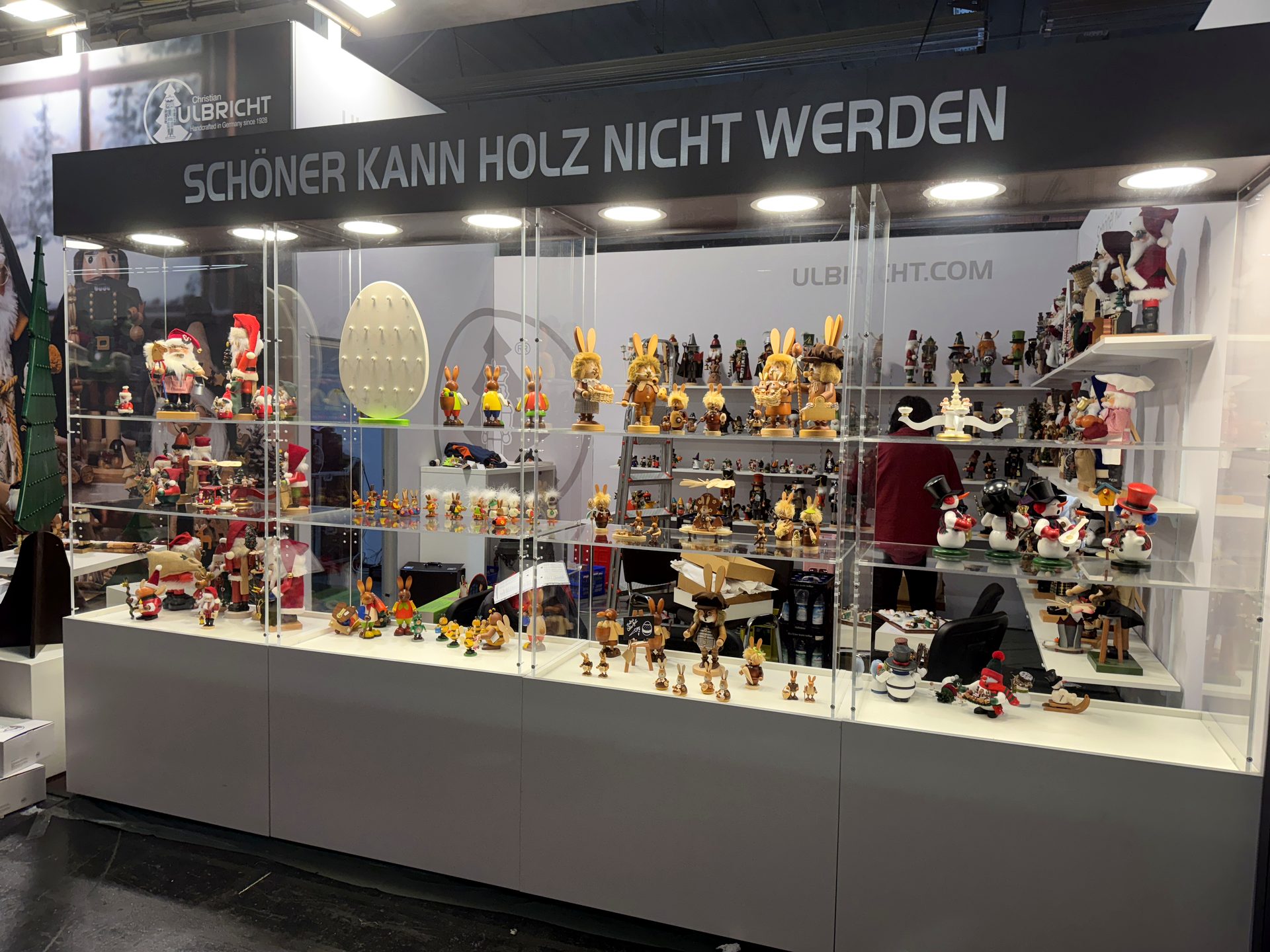 Beleuchtete Produktvitrine mit Deckenblende auf einem Messestand